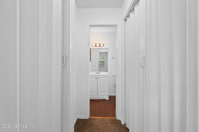 a view of a hallway with wooden floor and entryway