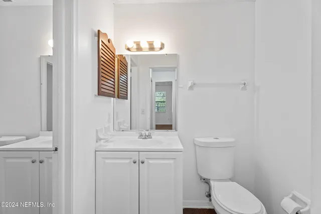 a bathroom with a toilet a sink and mirror