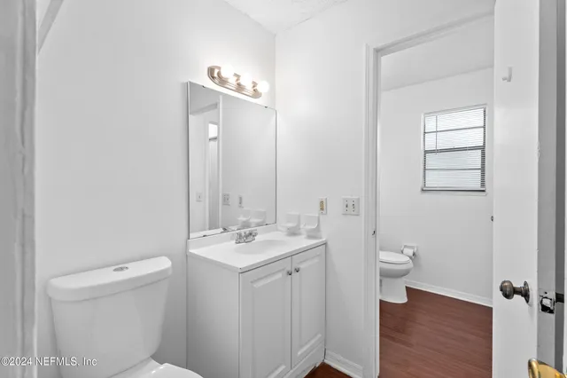 a bathroom with a toilet a sink and mirror