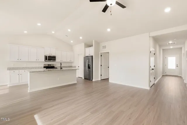 a view of kitchen with refrigerator microwave and stove
