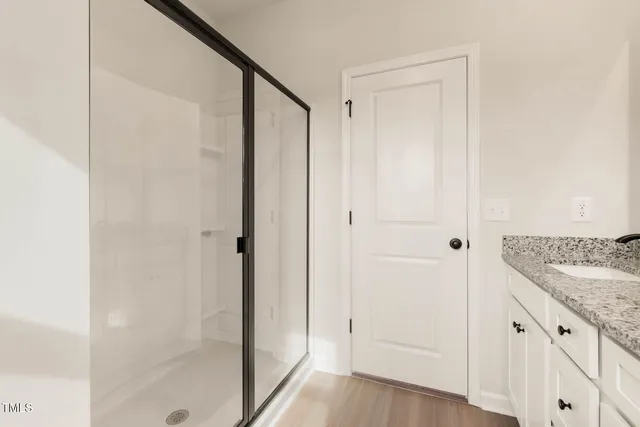 a bathroom with a granite countertop shower and a sink