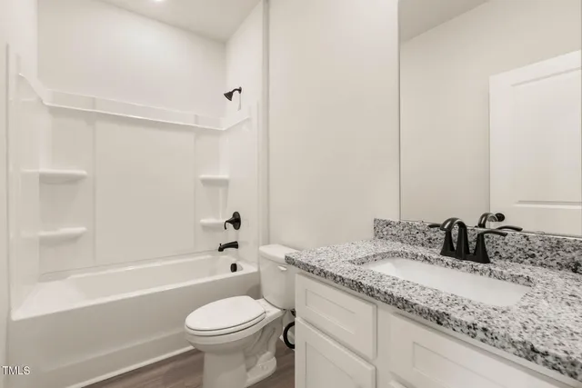 a bathroom with a granite countertop sink a toilet and a bathtub