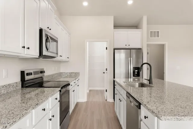 a kitchen with stainless steel appliances granite countertop a sink stove and refrigerator