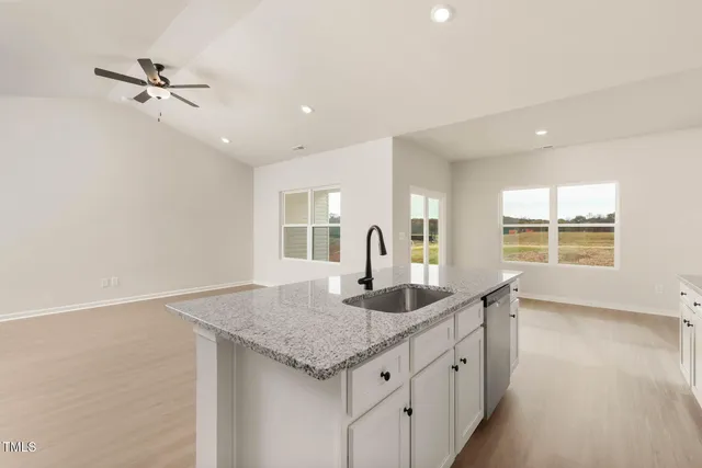 a kitchen with granite countertop a sink and chandelier