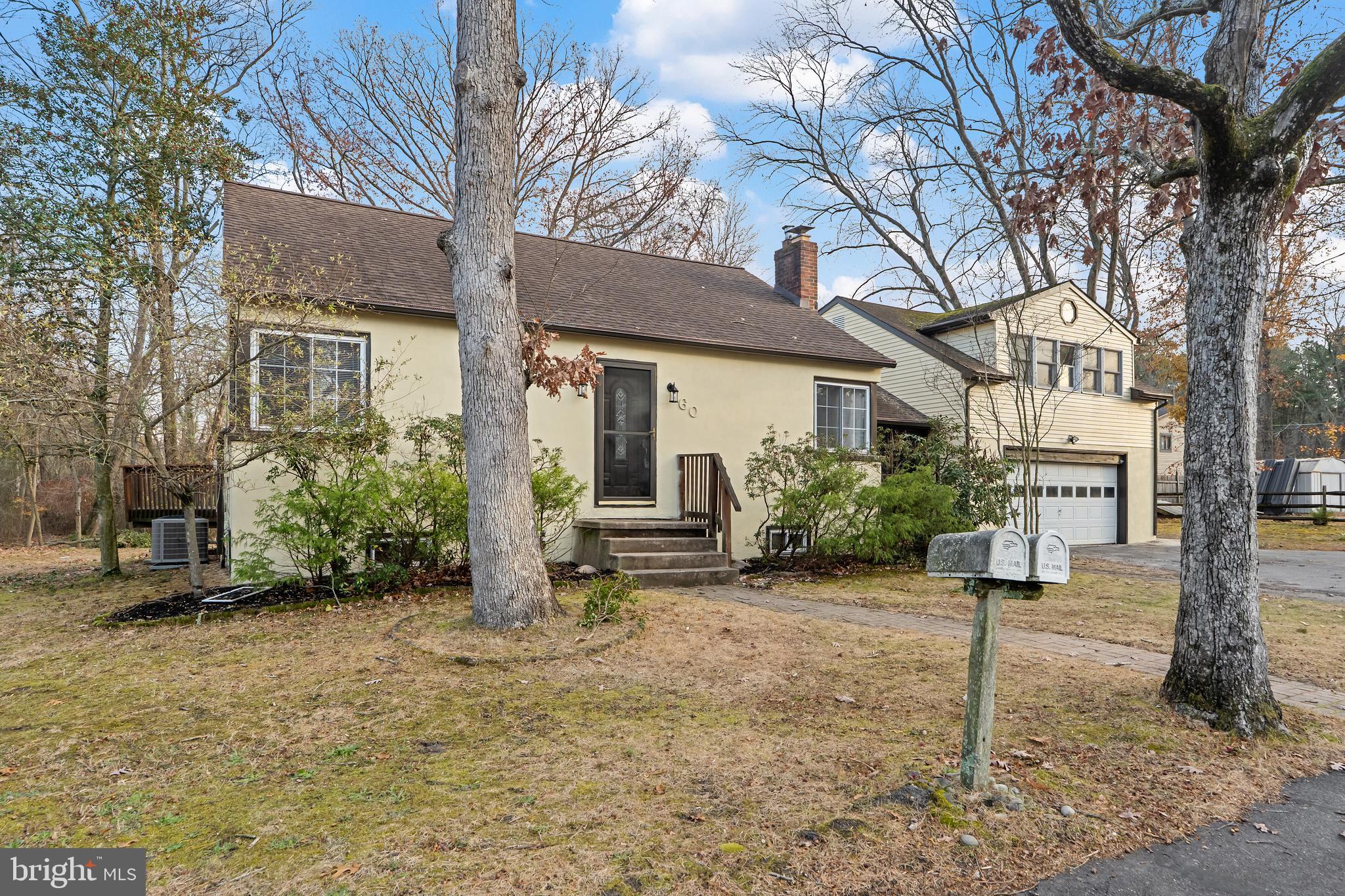 a view of a house with a yard and large tree
