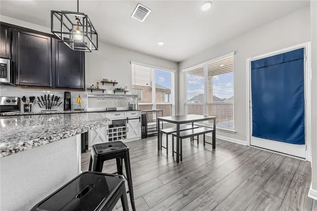 a kitchen with a table chairs sink and cabinets