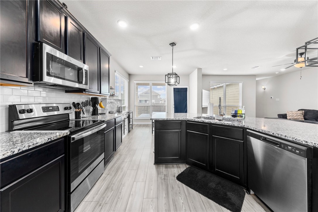 1906 Longmire Loop Temple, TX 76502 - Photo 8 of 32 a kitchen with stainless steel appliances granite countertop sink stove and refrigerator