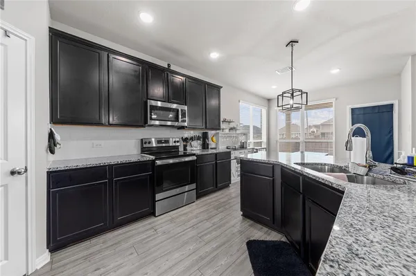 a kitchen with granite countertop stainless steel appliances and wooden cabinets