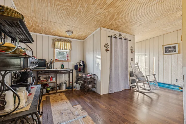 a bedroom with a bed a mirror on dresser and a table