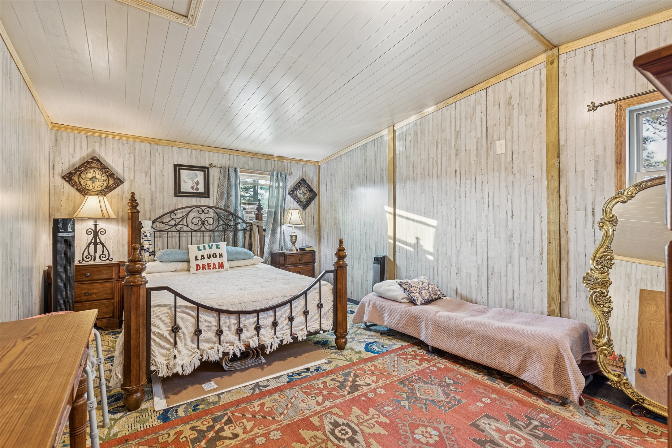 25 Pine Prairie School Road Huntsville, TX 77320 - Photo 10 of 15 a bedroom with a bed a mirror on dresser and a table