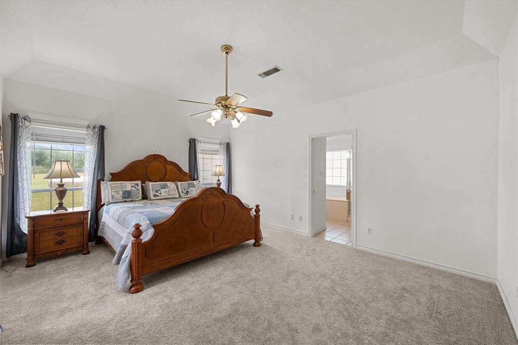 13021 Rudy's Way Streetman, TX 75859 - Photo 16 of 40 Primary bedroom near Richland Chambers Lake with soft carpet, natural light, and direct access to the ensuite bathroom.