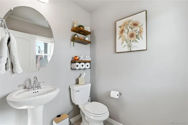 a bathroom with a toilet a sink and mirror