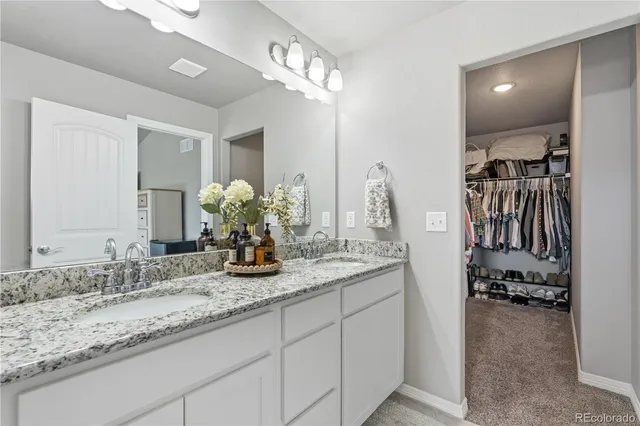 a bathroom with double vanity sinks a vanity and a mirror