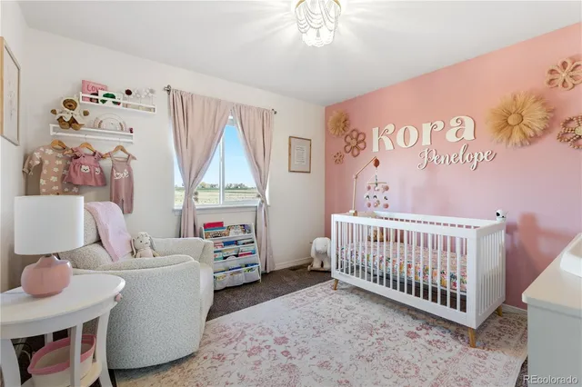 a living room with furniture and a baby crib