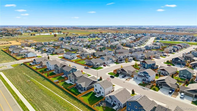 an aerial view of a city with lots of residential buildings and ocean view in back