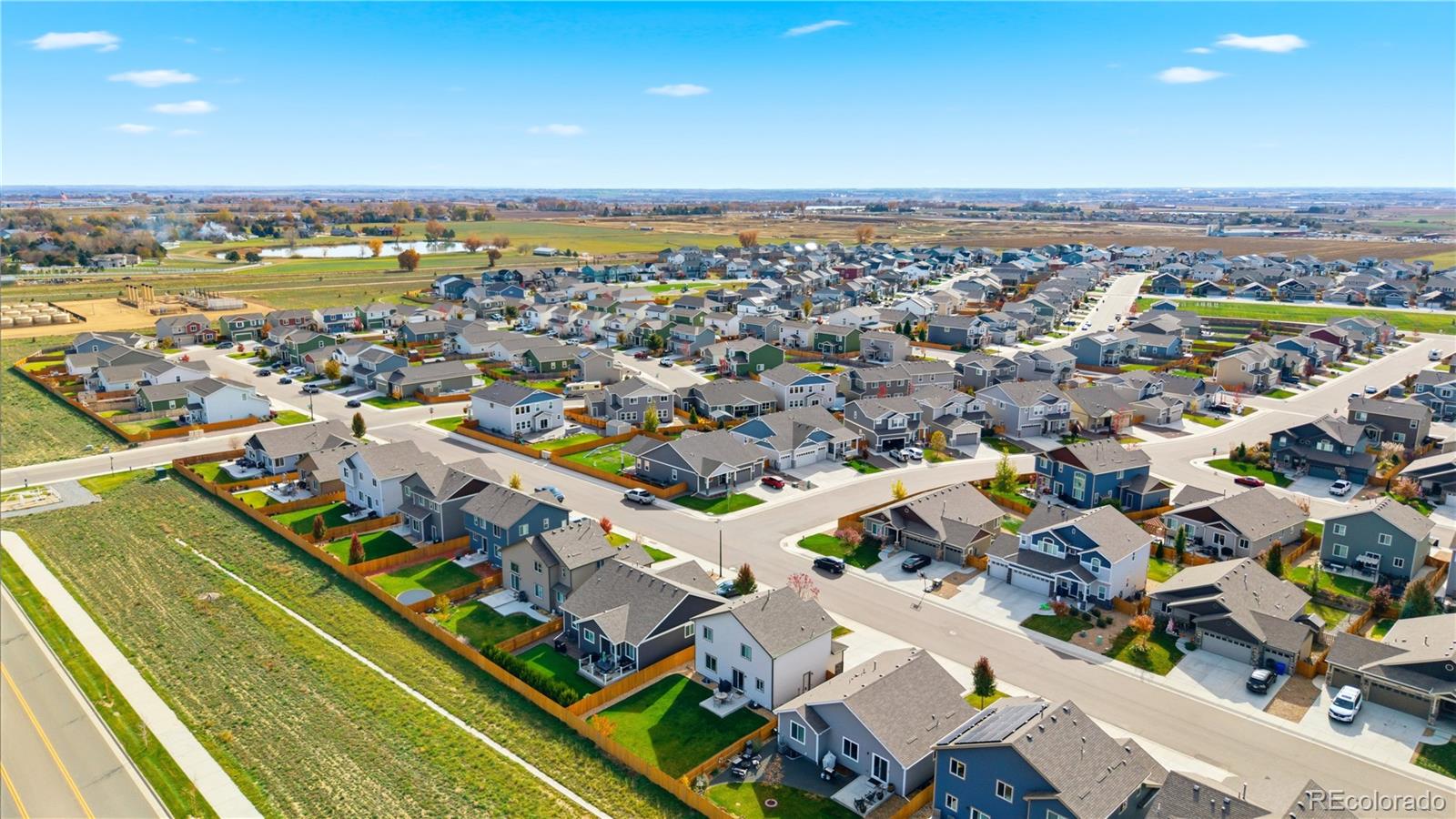 2173 Angus Street Mead, CO 80542 - Photo 26 of 28 an aerial view of a city with lots of residential buildings and ocean view in back