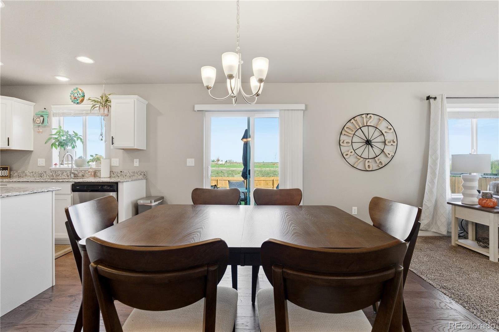 2173 Angus Street Mead, CO 80542 - Photo 10 of 28 a view of a dining room with furniture a chandelier and wooden floor