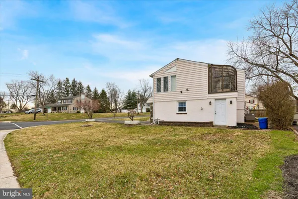 a view of a house with backyard and trees