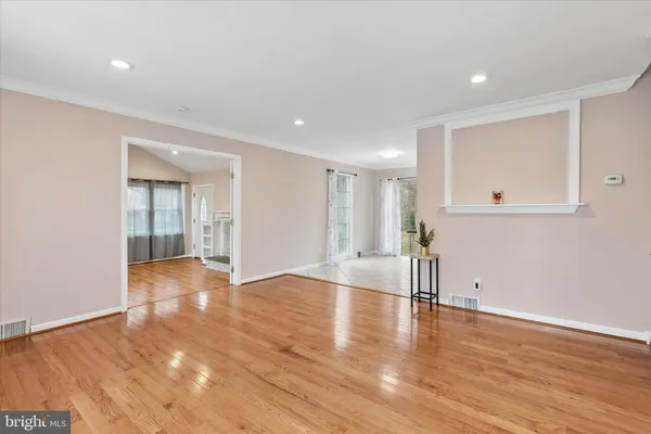 a view of empty room with wooden floor