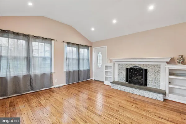 a view of an empty room with a fireplace and a window