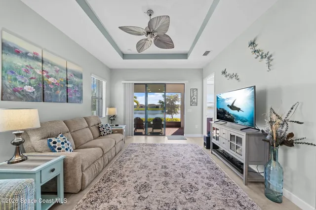 a living room with furniture a flat screen tv and a floor to ceiling window