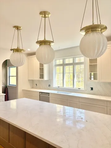 a kitchen with cabinets stainless steel appliances and wooden floor