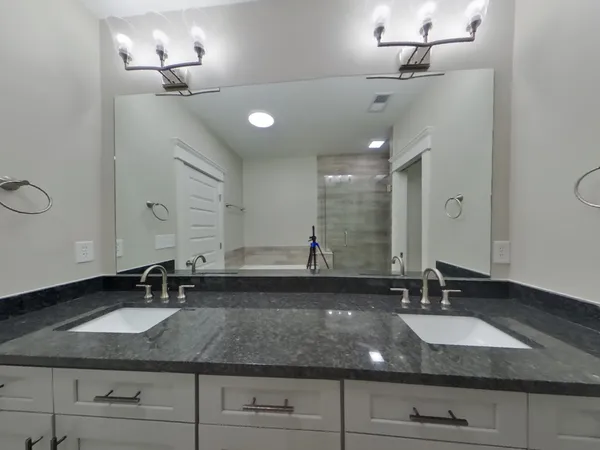 a bathroom with double vanity sinks and a mirror