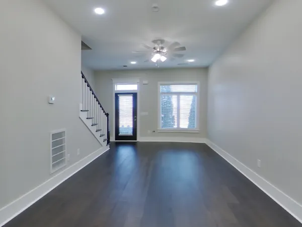 an empty room with wooden floor and window