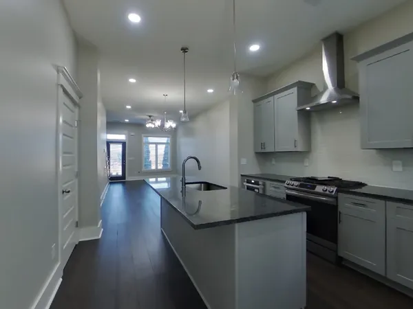 a kitchen with stainless steel appliances granite countertop a sink stove and refrigerator