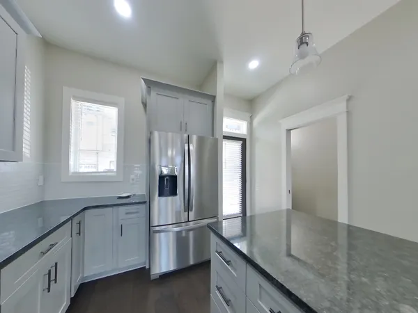 a kitchen with stainless steel appliances granite countertop a refrigerator and a sink