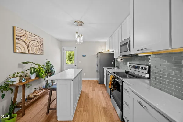 a kitchen with stainless steel appliances a stove refrigerator sink and microwave