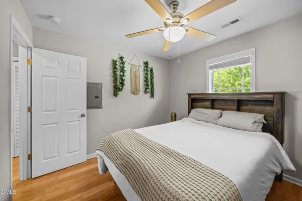 a bedroom with a large bed and a chandelier