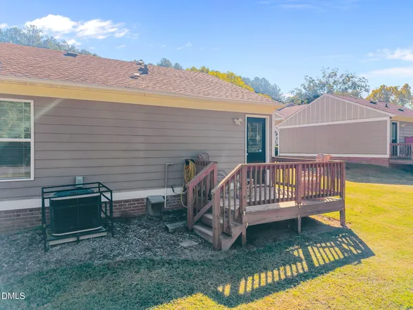 a view of a house with wooden deck and a yard