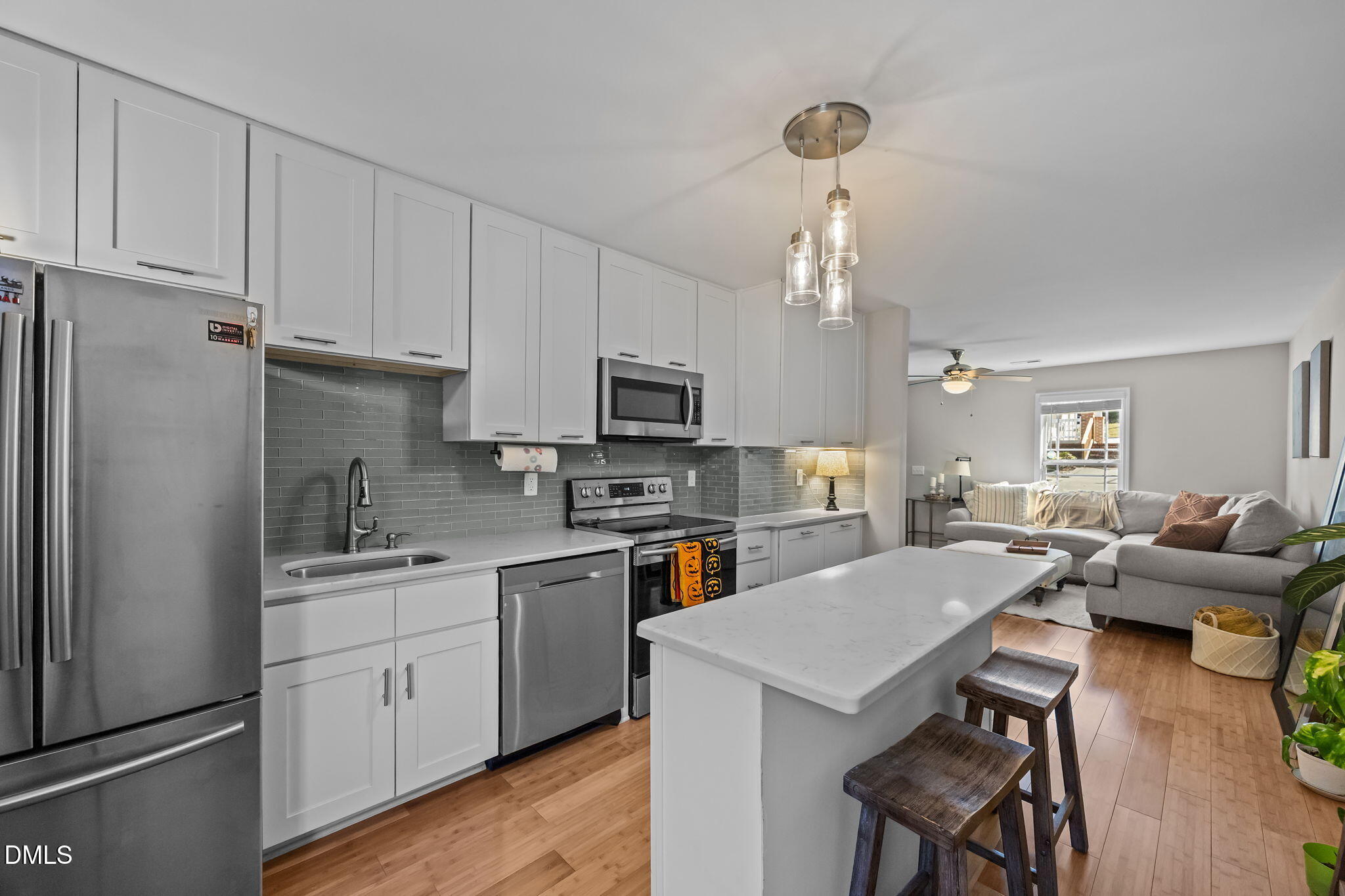 1316 South State Street, Unit D Raleigh, NC 27610 - Photo 9 of 36 a kitchen with a refrigerator a stove a sink dishwasher a dining table and chairs with wooden floor