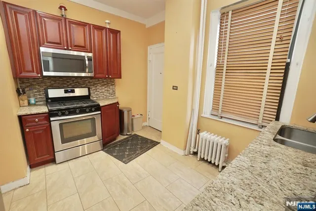 a bathroom with a granite countertop sink and a toilet
