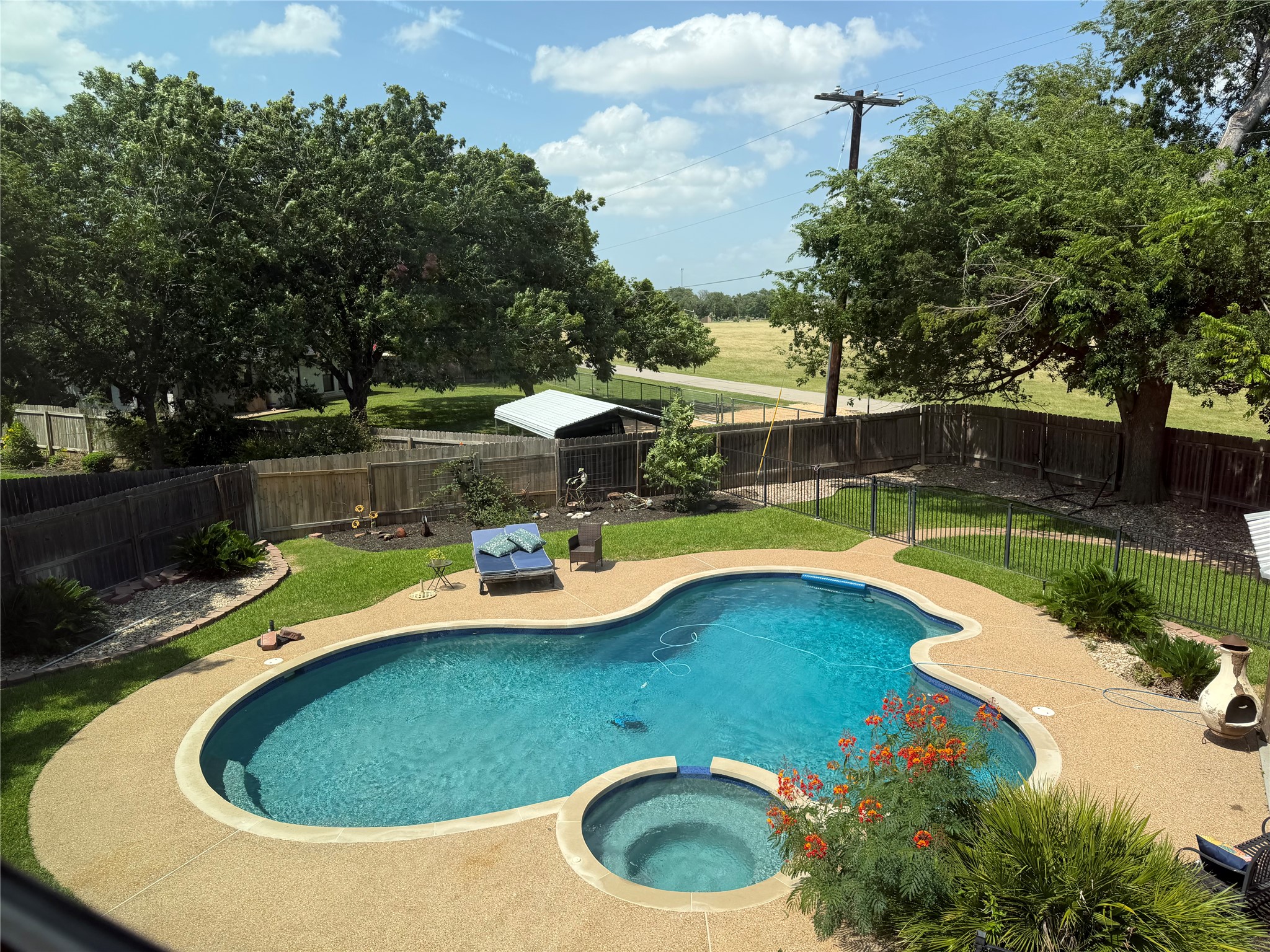 13 Oak View Round Rock, TX 78664 - Photo 4 of 30 A private backyard oasis features a free-form pool and integrated spa, surrounded by lush landscaping.