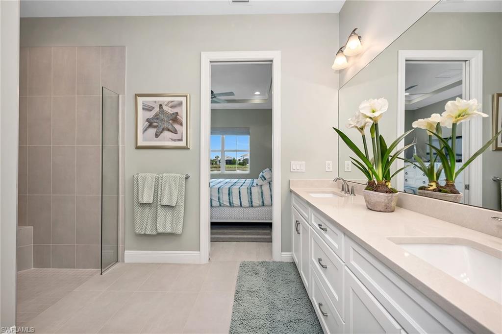 9020 Mayreau Way Naples, FL 34114 - Photo 8 of 28 a bathroom with a double vanity sink and a window