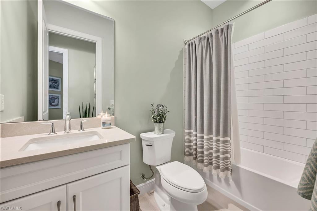 9020 Mayreau Way Naples, FL 34114 - Photo 10 of 28 a bathroom with a sink a toilet a mirror and shower