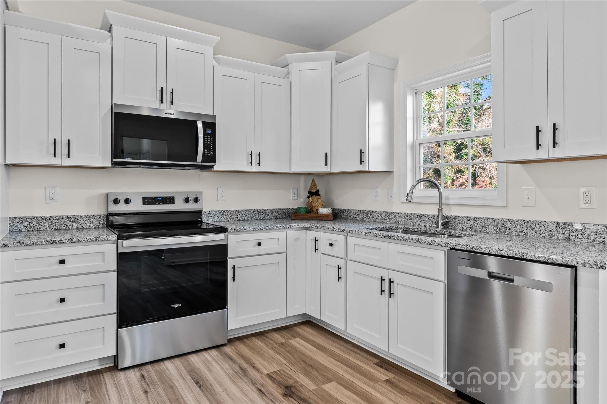 402 North Ward Avenue High Point, NC 27262 - Photo 6 of 24 a kitchen with stainless steel appliances granite countertop a stove a microwave and a white cabinets