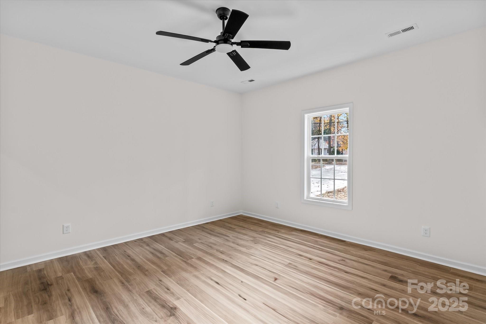 402 North Ward Avenue High Point, NC 27262 - Photo 10 of 24 an empty room with wooden floor ceiling fan and windows