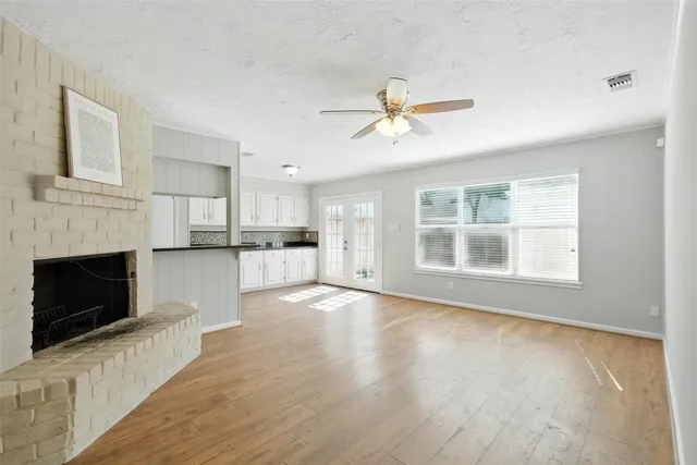 a view of a kitchen with wooden floor and a fireplace