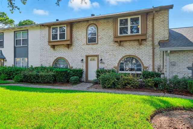 a front view of a house with plants and a yard