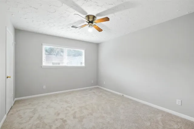 a view of an empty room with a ceiling fan