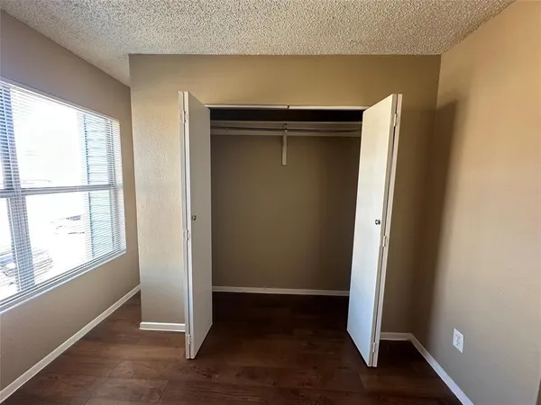 an empty room with wooden floor and window