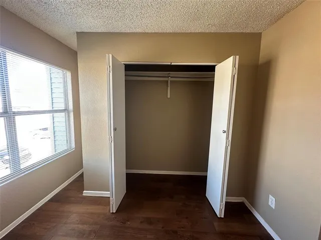 an empty room with wooden floor and window