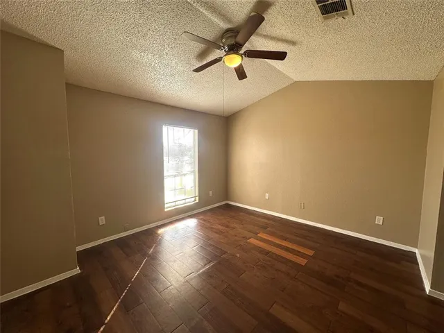 an empty room with windows and fan