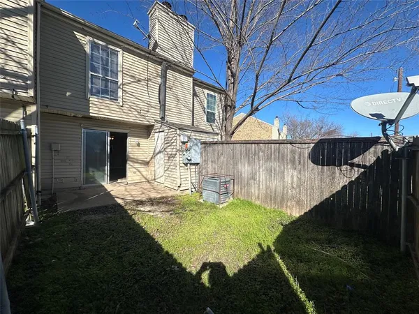 a view of a backyard with table and chairs with wooden fence