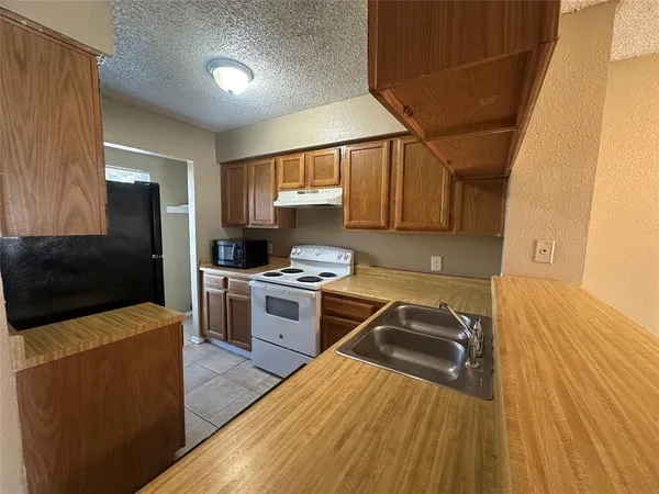a kitchen with a stove a refrigerator and a sink