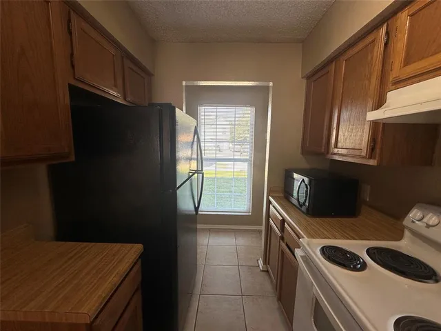 a kitchen with a refrigerator and a stove top oven