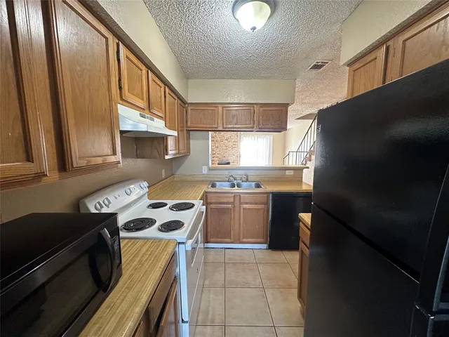 a kitchen with a refrigerator and a stove